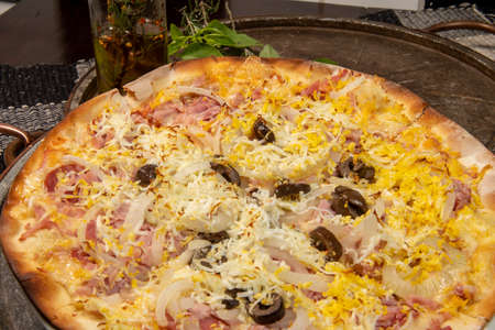 Brazilian Portuguese-style pizza with ham, egg, pepper, onion, mozzarella, top viewの写真素材