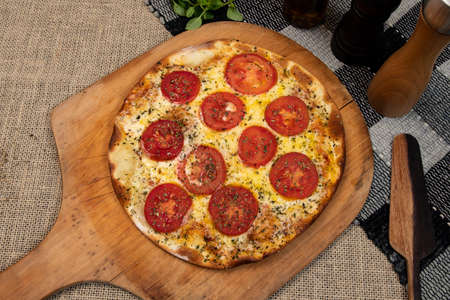 Neapolitan Brazilian pizza with mozzarella cheese and tomato slices with oregano, top viewの写真素材
