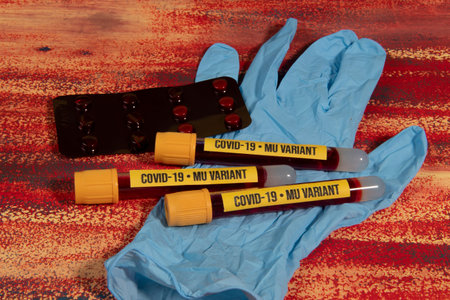 Vacuum tube with blood sample for Mu variant test over a glove