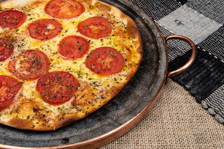 Neapolitan Brazilian pizza with mozzarella cheese and tomato slices with oregano, top viewの写真素材