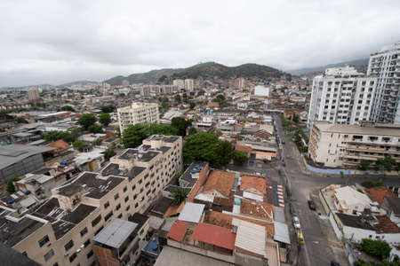 Rio, Brazil - September 16, 2021: aerial view of densely populated urban area with houses and buildings and mountain in the background on cloudy day.のeditorial素材