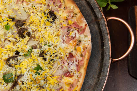 Brazilian Portuguese-style pizza with ham, egg, pepper, onion, mozzarella, top viewの写真素材
