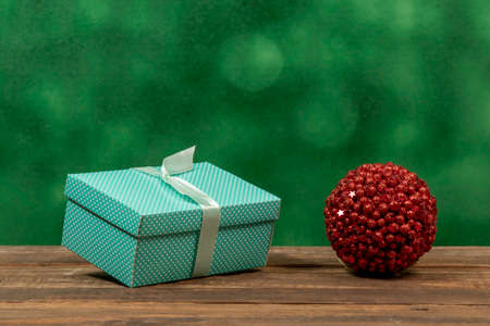 green gift box and red christmas ball in front viewの写真素材