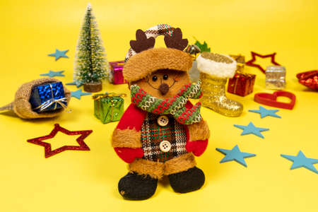 Felt doll dressed in winter clothes and featuring a Christmas moment, with elements in the backgroundの写真素材