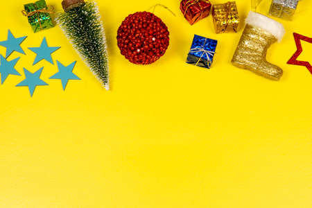 Christmas elements with space for text with star, ball, gift box in a yellow backgroundの写真素材