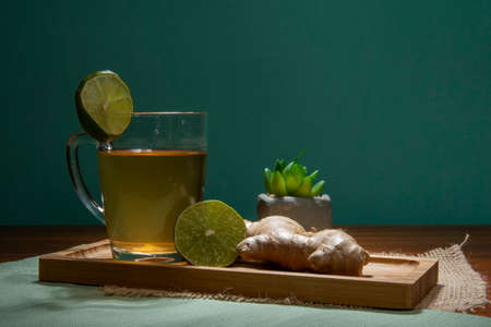 cup of tea with lemon, ginger and honey on a tableの写真素材