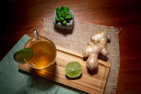 cup of tea with lemon, ginger and honey on a tableの写真素材