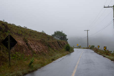 two-way road in rural area with trees in foggy day. in the carの写真素材