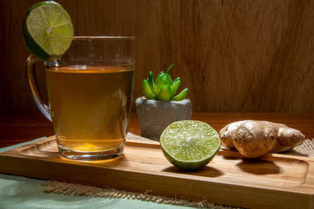 cup of tea with lemon, ginger and honey on a tableの写真素材