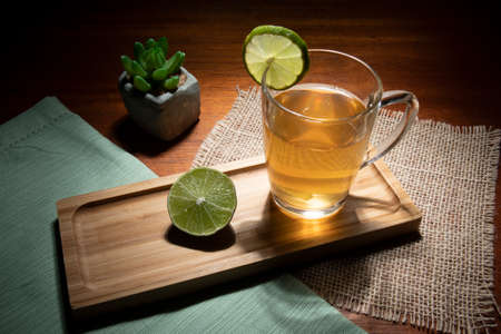 cup of tea with lemon, ginger and honey on a tableの写真素材