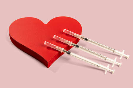 diabetes and heart related problems, showing syringe and a heart shapeの写真素材