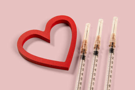 diabetes and heart related problems, showing syringe and a heart shapeの写真素材