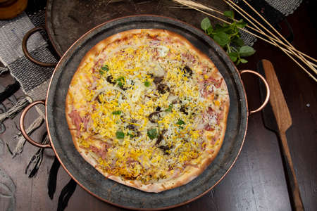 Brazilian Portuguese-style pizza with ham, egg, pepper, onion, mozzarella, top viewの写真素材