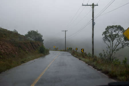 two-way road in rural area with trees in foggy day. in the carの写真素材