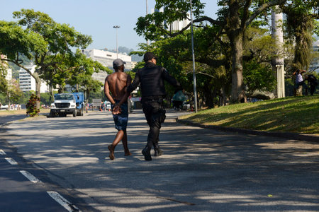 Rio de Janeiro, Brazil - March 13, 2022: policeman arresting and handcuffing a person in Botafogo...