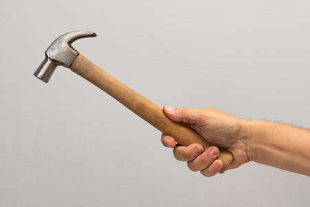 Man's hand holds a tool isolated on gray background.の写真素材