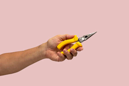 Man's hand holds a tool isolated on pink background.の写真素材