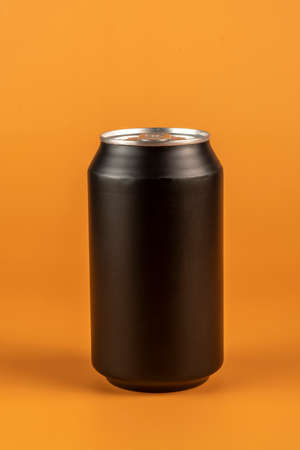 Black aluminum can isolated on orange backgroundの写真素材