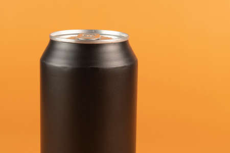 Black aluminum can isolated on orange backgroundの写真素材