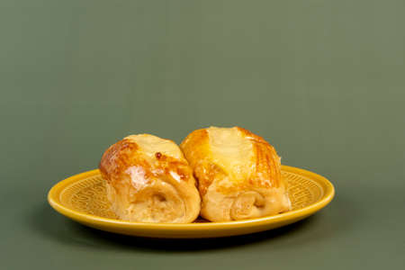 Brazilian sweet bread from bakery on yellow plate and green backgroundの写真素材