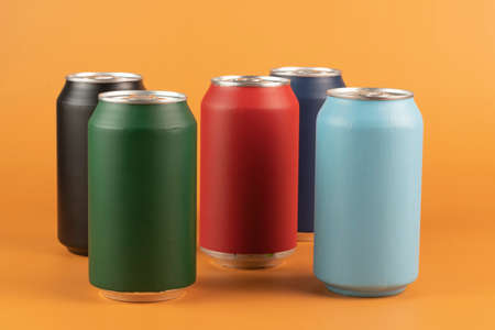 Several color aluminum can isolated on orange backgroundの写真素材