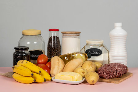 Brazilian basic food basket completed composed of 13 products: meat, milk, rice, beans, bread, flour, potato, tomato, bread, coffee, banana, sugar, oil and butterの写真素材