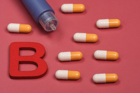 yellow and white medicine capsules on red background and insulin pen
