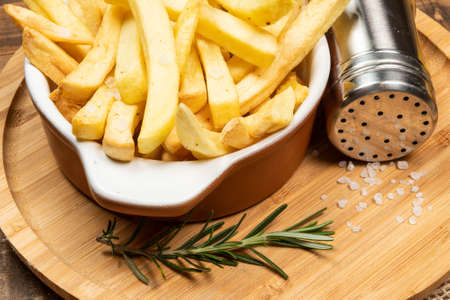 Tasty french fries on plate on wooden table backgroundの写真素材