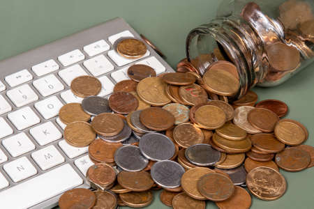 counting coins to spend on internet purchasesの写真素材