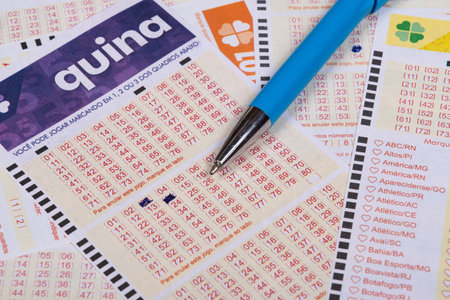 Rio, Brazil - July 20, 2022: person filling out Caixa Economica Federal lottery card, the only official betting method in Brazilのeditorial素材