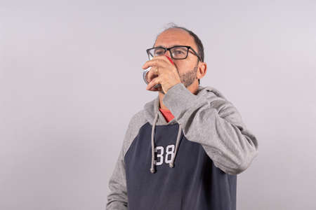 Portrait of happy senior in casual outfit and drinking sodaの写真素材