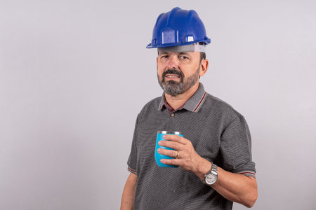Portrait of happy senior worker in casual outfit and drinking coffee