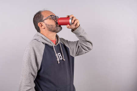 Portrait of happy senior in casual outfit and drinking sodaの写真素材