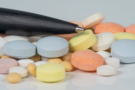 Medicines (tablets, capsules, pills) of different sizes and colors, stacked in bulk. Illness,...