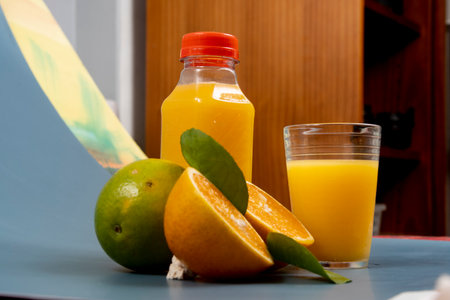 Natural orange juice in the glass with bottle on the sideの写真素材