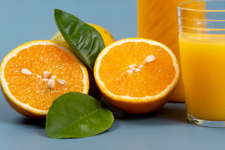 Natural orange juice in the glass with bottle on the side and leafsの写真素材