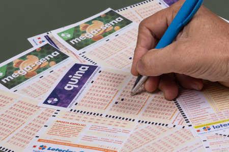 Rio, Brazil - July 20, 2022: person filling out Caixa Economica Federal lottery card, the only official betting method in Brazilのeditorial素材