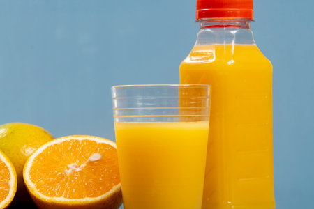 Natural orange juice in the glass with bottle on the sideの写真素材