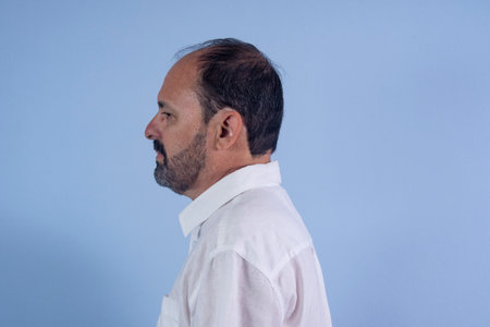 Portrait of 60 years old bearded man on blue backgroundの写真素材
