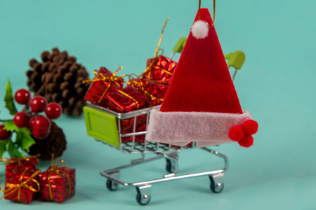 Santa hat miniature in the foreground with blurred shopping cart in the backgroundの写真素材