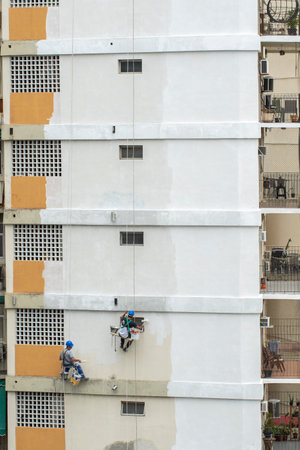 Rio, Brazil - november 04, 2022 - painter works on residential building facade recovery by rope as a climberのeditorial素材