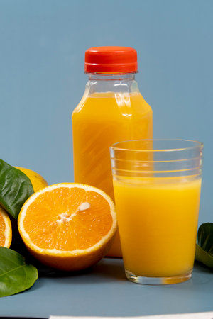 Natural orange juice in the glass with bottle on the sideの写真素材