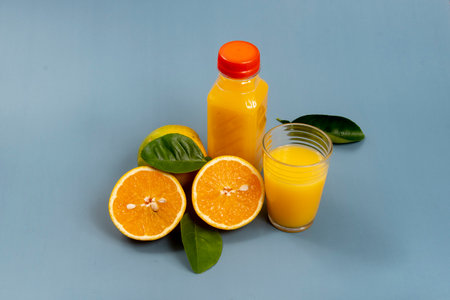 Natural orange juice in the glass with bottle on the sideの写真素材