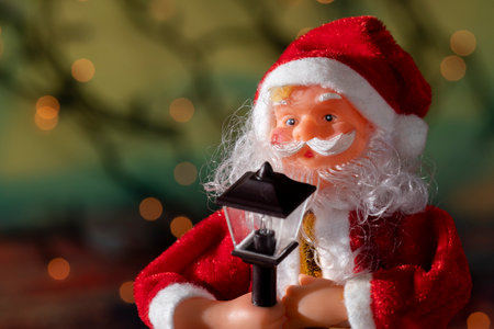 Santa claus doll with blurred christmas lights backgroundの写真素材
