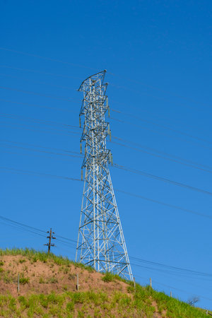 Electric power transmission tower in rural area with blue sky background Electric power distribution infrastructureの写真素材