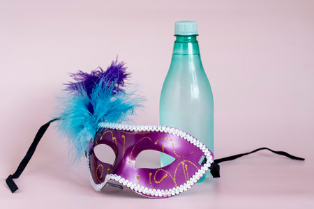 Hydration concept, drinking a lot of water during carnival holiday, bottle with venetian mascaraの写真素材