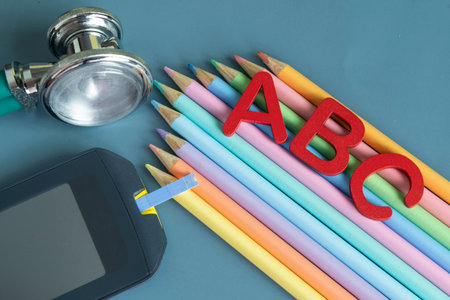 Back to school concept for kids with diabetes represented by colored pencils and glucometerの写真素材
