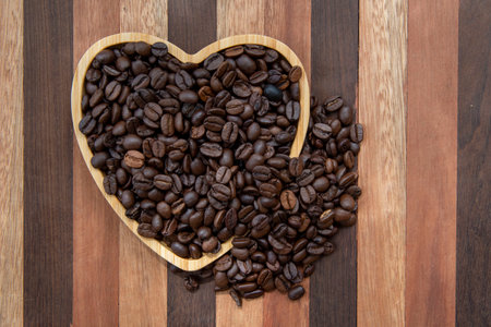 coffee beans in heart-shaped tray representing love of coffeeの写真素材
