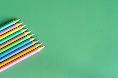 Pastel colored pencils, top view on green background, illustration concept, background and education and back to schoolの写真素材