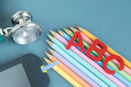 Doctor's stethoscope and colorful pencils on blue background.の写真素材